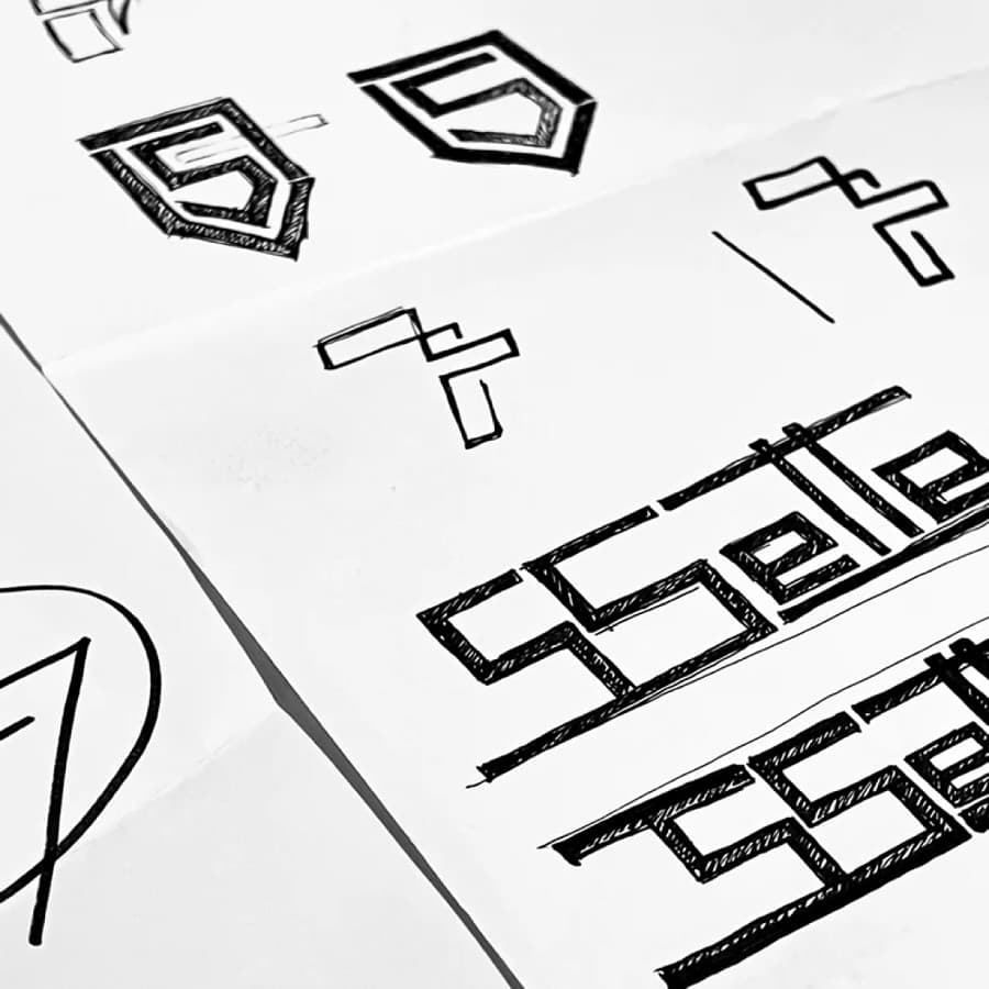Pencil sketches of the Sette S mark on paper, the studio drawing the logo by hand
